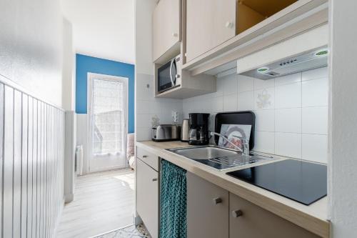 une cuisine avec un évier et un micro-ondes dans l'établissement 19 - Le Faucon - Village vacances, à Maché