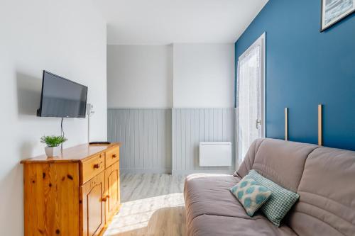 un salon avec un canapé et une télévision à écran plat dans l'établissement 19 - Le Faucon - Village vacances, à Maché