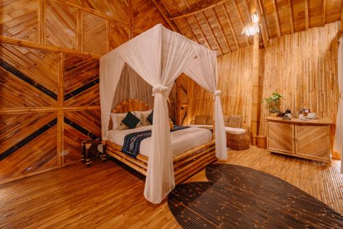 a bedroom with a canopy bed in a wooden room at Trivana Sanctuary by Arcada Bali in Sidemen