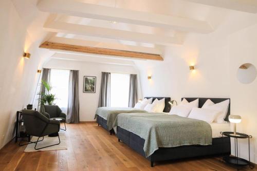 a bedroom with two beds and a chair in it at Apartments Weinhimmel in Krems an der Donau