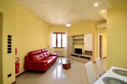 Una sala de estar con un sofá rojo y una mesa. en HC - CloHouse Spacious Flat, en Roma