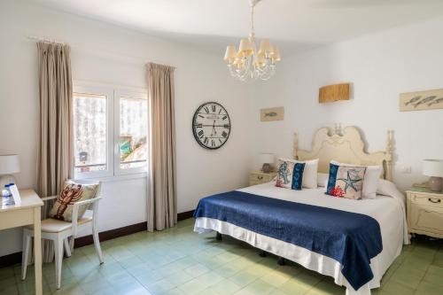 a bedroom with a bed and a clock on the wall at La Goleta in Llança