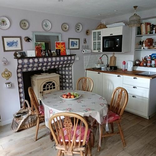 Il comprend une cuisine et une salle à manger avec une table et une cheminée. dans l'établissement Avenue du Château, à Saint-Just