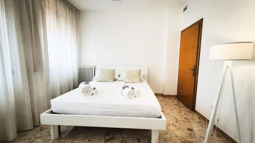a bedroom with a white bed with two towels on it at Canal Bellavista by Ca-Sa Check in Chioggia