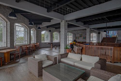 a living room with a couch and tables and windows at Plataran Menjangan Resort and Spa - CHSE Certified in Banyuwedang