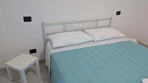 a bedroom with a white bed and a white table at Appartamento in residence "CASA DAMIA" in Taranto