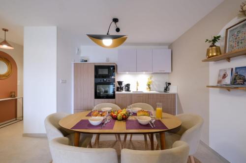 une cuisine et une salle à manger avec une table et des chaises en bois dans l'établissement Reflet d'ô Retz - 4pers Plage Montbeau, à Pornic