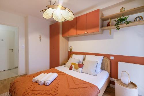 une chambre avec un grand lit avec une couverture orange dans l'établissement Reflet d'ô Retz - 4pers Plage Montbeau, à Pornic