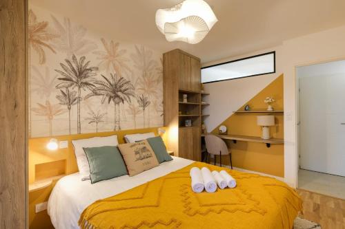 une chambre avec un lit avec un couvre-lit jaune dans l'établissement Reflet d'ô Retz - 4pers Plage Montbeau, à Pornic