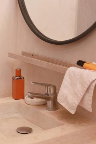 a bathroom sink with a faucet and a mirror at Jnan Lotf Marrakech - Le Jardin de la Bienveillance in Marrakech