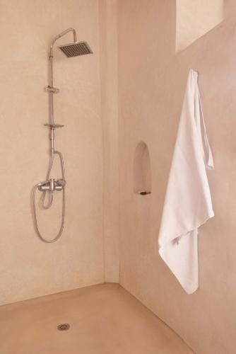 a shower with a white towel hanging on a wall at Jnan Lotf Marrakech - Le Jardin de la Bienveillance in Marrakech