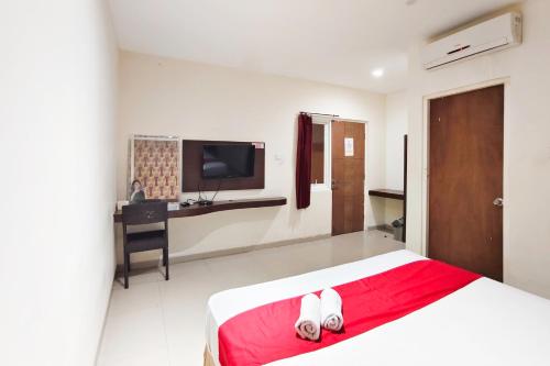 a bedroom with a bed and a desk and a television at TwoSpaces Living at Kutisari Residence, Surabaya in Surabaya