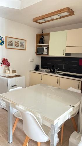 a kitchen with a white table and chairs in a room at Il Giardino dei Limoni in Vieste