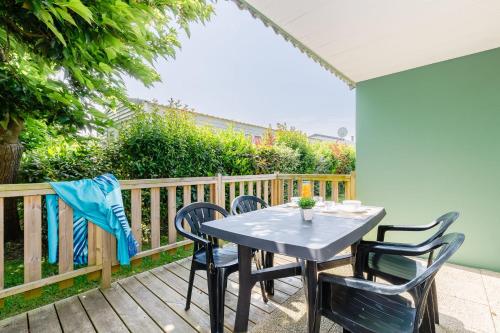 un patio avec une table et des chaises sur une terrasse dans l'établissement 26 - La Mouette - Village vacances, à Maché