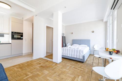 une chambre blanche avec un lit et une cuisine dans l'établissement Cosy Rooftop - Happy Rentals, à Nice