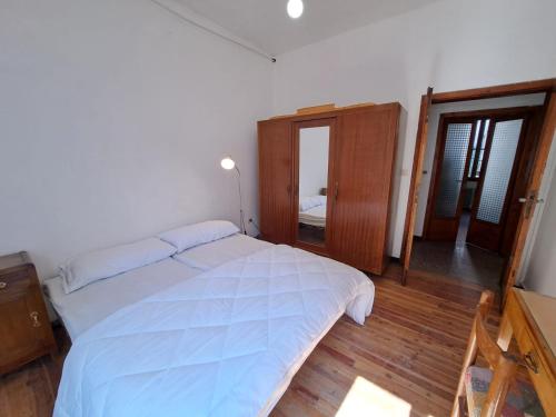 a bedroom with a large bed and a mirror at GREEN DOLOMYTE Apartment in Schilpario