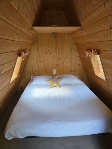 une chambre avec un lit dans une cabane en bois dans l'établissement Eté indien-hôtellerie de plein air, à Wimereux