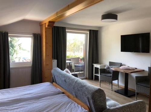 a hotel room with a bed and a desk and a television at Pension Kuntschner in Mittersill