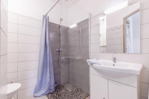 une salle de bain blanche avec un lavabo et une douche dans l'établissement 27 - La Perdrie - Village vacances, à Maché