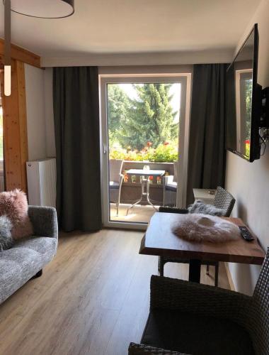 a living room with a table and a large window at Pension Kuntschner in Mittersill