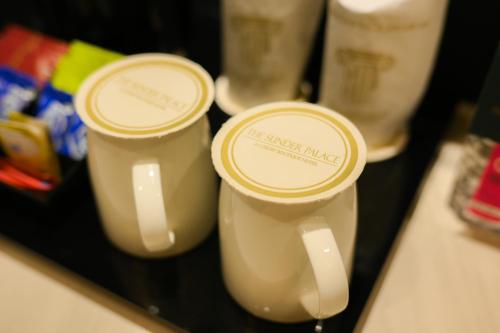 two white cups sitting on a table with labels on them at The Sunder Palace-Jaipur City Centre Hotel in Jaipur