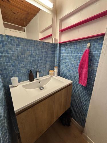 une salle de bain avec un lavabo et une serviette rouge dans l'établissement Studio Bougainvillier, à La Seyne-sur-Mer