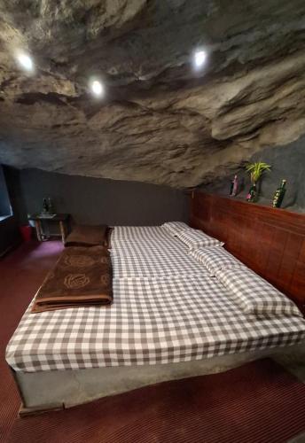 a bed in a room with a stone wall at Escape Natural Farm Stay - Cave 2 in Kanthalloor