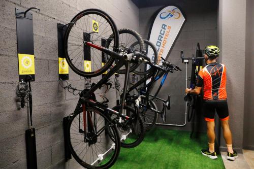 a man standing next to a bike hanging on a wall at Llaut Boutique Hotel in Can Picafort