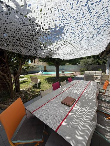 une table avec un livre en haut dans l'établissement Superbe Villa climatisée avec piscine, à Lavérune