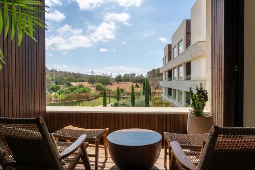 a balcony with chairs and a table and a view at Kimpton Aysla Mallorca by IHG in Santa Ponsa