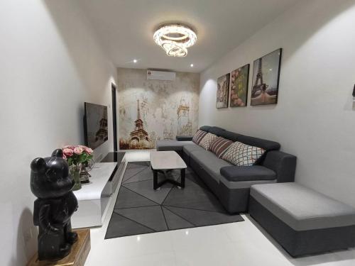 クチンにあるEyvone Homestay Princeton Suites Kuching Airportのソファとテーブルのあるリビングルーム