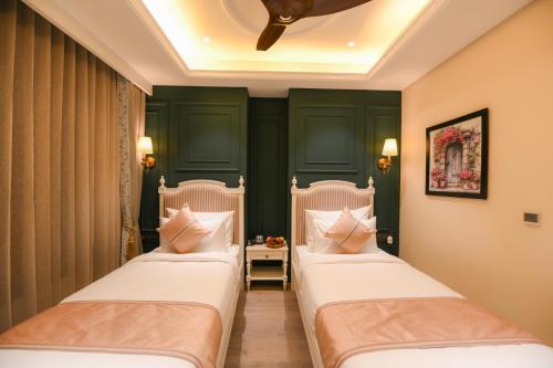 two beds in a room with green walls at The Sunder Palace-Jaipur City Centre Hotel in Jaipur