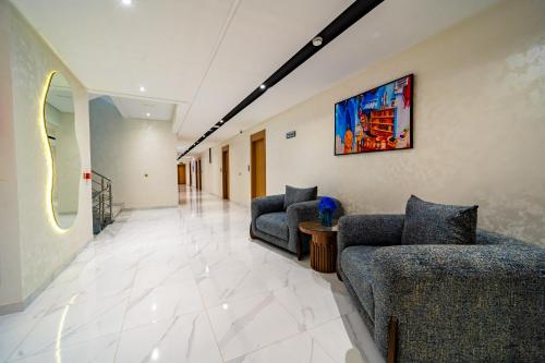 a living room with couches and a painting on the wall at Rafiny Hôtel in Ksar el Kebir