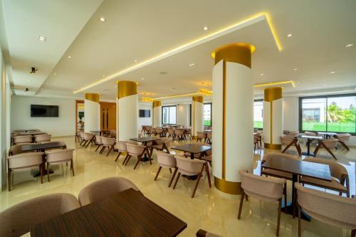 a restaurant with tables and chairs in a room at Rafiny Hôtel in Ksar el Kebir