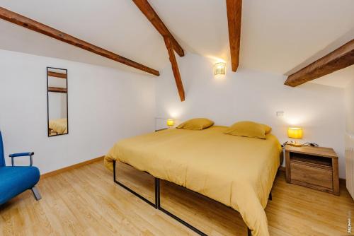 a bedroom with a bed and a blue chair at L'échappée Gaillacoise in Gaillac