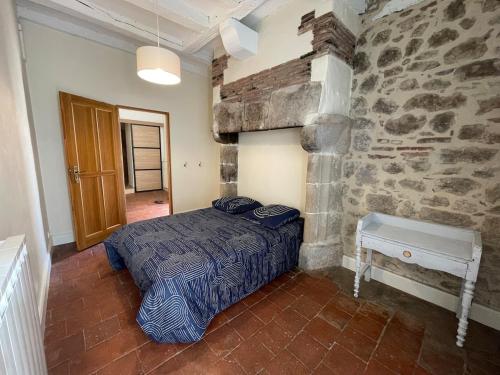 une chambre avec un lit et un mur en pierre dans l'établissement Maison de vacances en pierre, à Saint-Sylvestre-sur-Lot