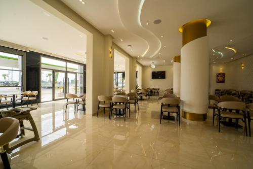 a restaurant with tables and chairs in a building at Rafiny Hôtel in Ksar el Kebir