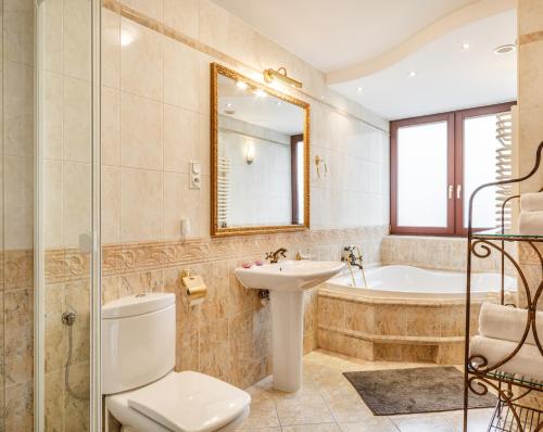 a bathroom with a toilet and a sink and a tub at Apartament nad Cukiernią in Zakopane