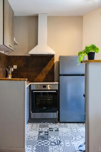 Il comprend une cuisine équipée d'un réfrigérateur et d'une cuisinière. dans l'établissement Le Duplex Gaillacois, à Gaillac