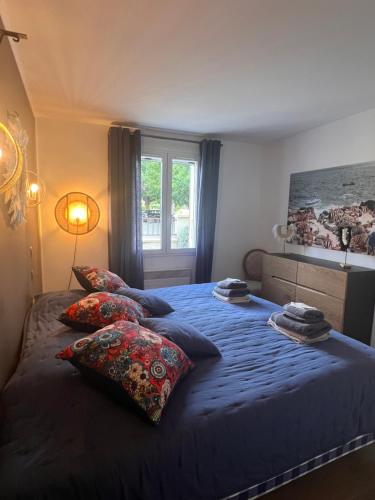 - une chambre avec un lit bleu avec des oreillers et une fenêtre dans l'établissement Haus PETIT REVE in Oppède, à Oppède