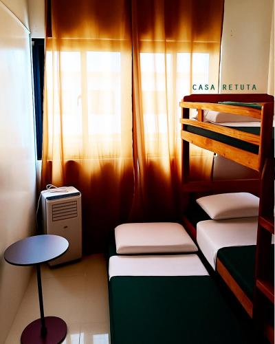 a small room with two bunk beds and a table at Casa Retuta - Guest House for Groups in San Vincente