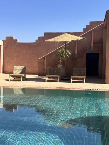a swimming pool with two chairs and an umbrella at Villa 4 chambres avec grande piscine privée in Marrakech