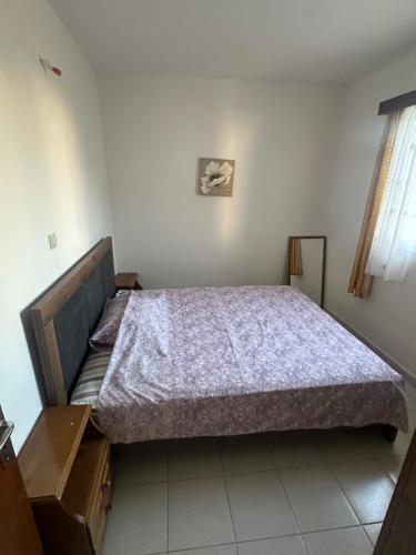 a bedroom with a bed with a purple comforter at KakLeCharaki in Haraki