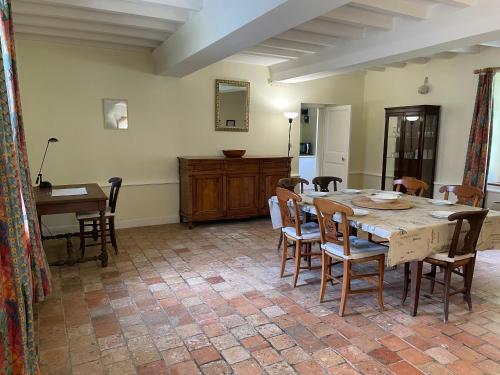 une salle à manger avec une table et des chaises en bois dans l'établissement Maison spacieuse entre Bois Mer et Marais, à Canchy