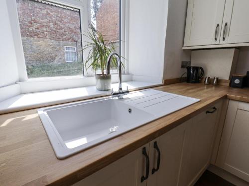 a kitchen counter with a sink and a window at Hemdin Cottage in Pickering