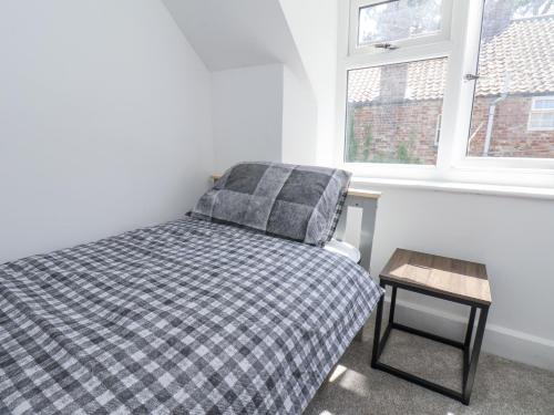 a small bedroom with a bed and a table at Hemdin Cottage in Pickering