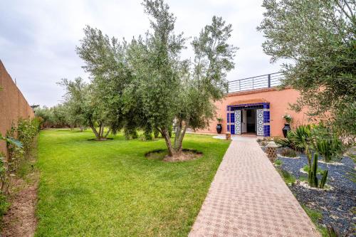 a walkway in front of a building with trees at Villa privée a Agafay a Marrakech 