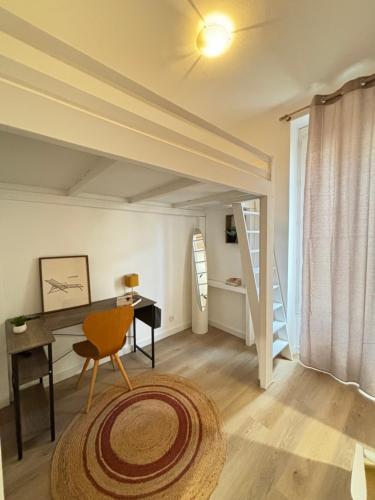 une chambre mansardée avec un bureau et une chaise et un bureau dans l'établissement Appartement 4 personnes à 500 mètres des plages de sable, à Cannes