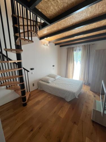 une chambre avec un lit et un escalier en colimaçon dans l'établissement Villa Les Chênes, à Saint-Victor-la-Coste