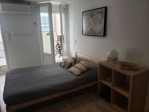 une chambre avec un lit, une table et une fenêtre dans l'établissement Piscine, 3 chbs, terrasse, vue mer, à Palavas-les-Flots